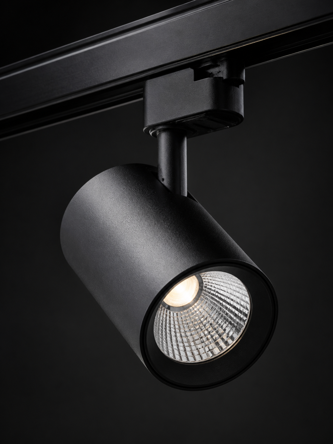 Professional product photograph of black track lighting fixture with LED spotlight head
