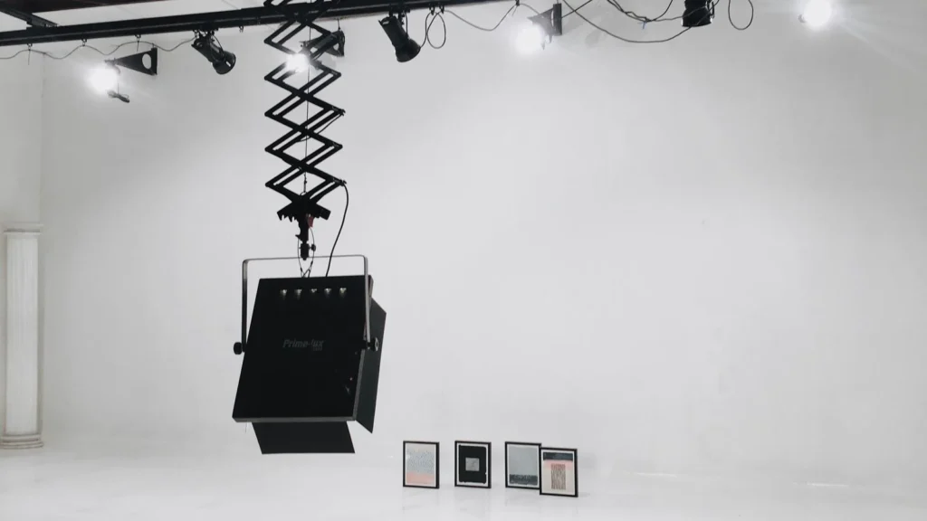 Lux vs lumens lighting metric diagram shown in a contemporary art gallery with LED track lighting on a painting
