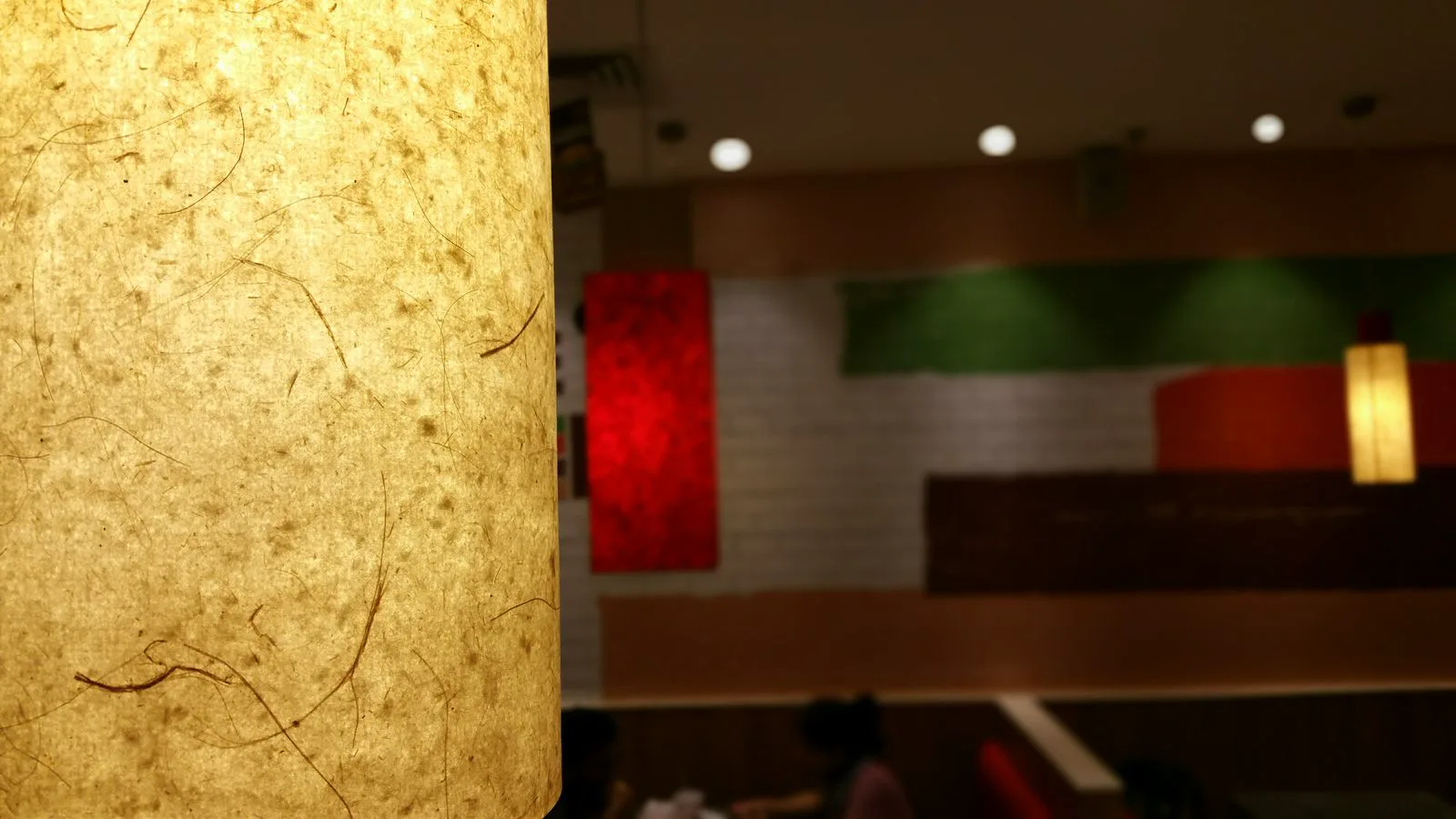 Cozy restaurant with warm dimmable track lighting at 100 to 200 lux ambient creating intimate atmosphere