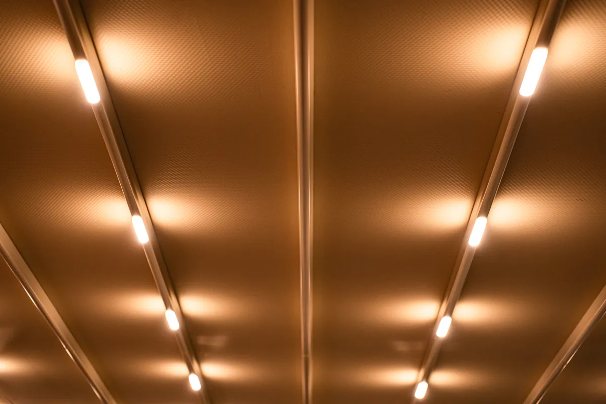 Suspended linear LED light fixtures on a minimalist ceiling providing even office lighting