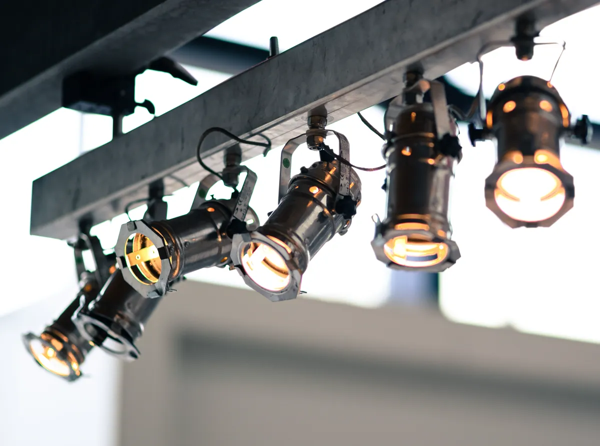 Adjustable LED track lighting heads aiming focused beams at workspace displays in a commercial office