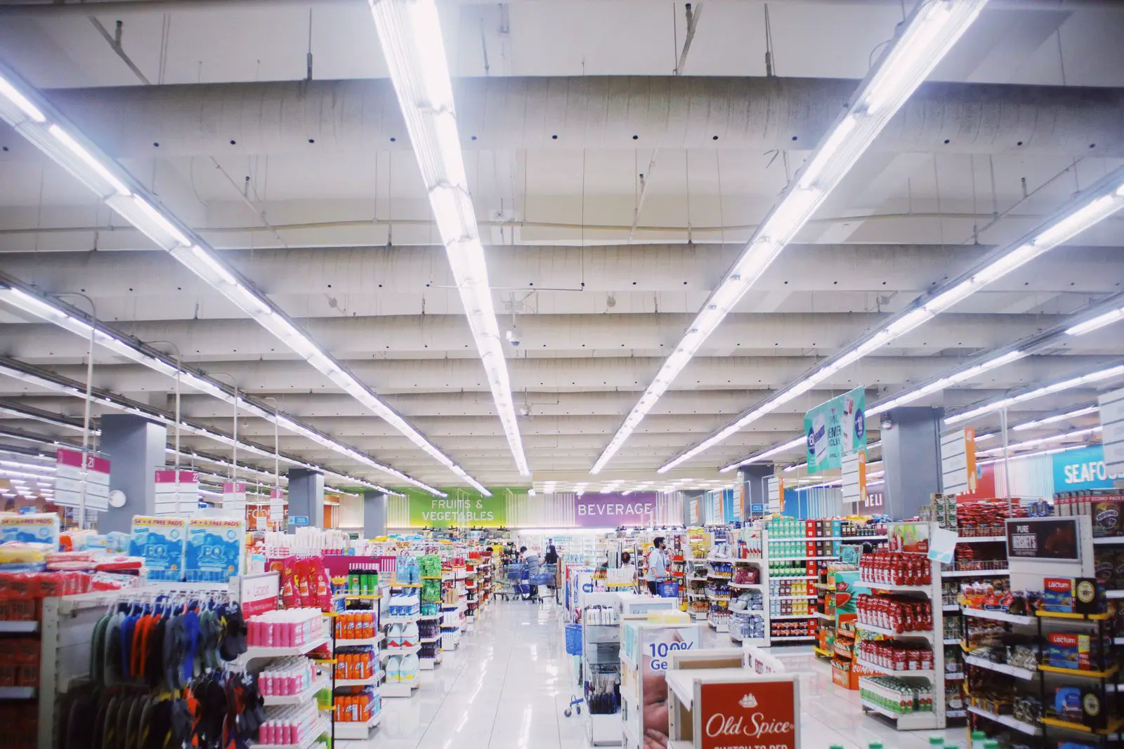 Bright supermarket interior with rows of products under commercial lighting delivering 400 to 700 lux