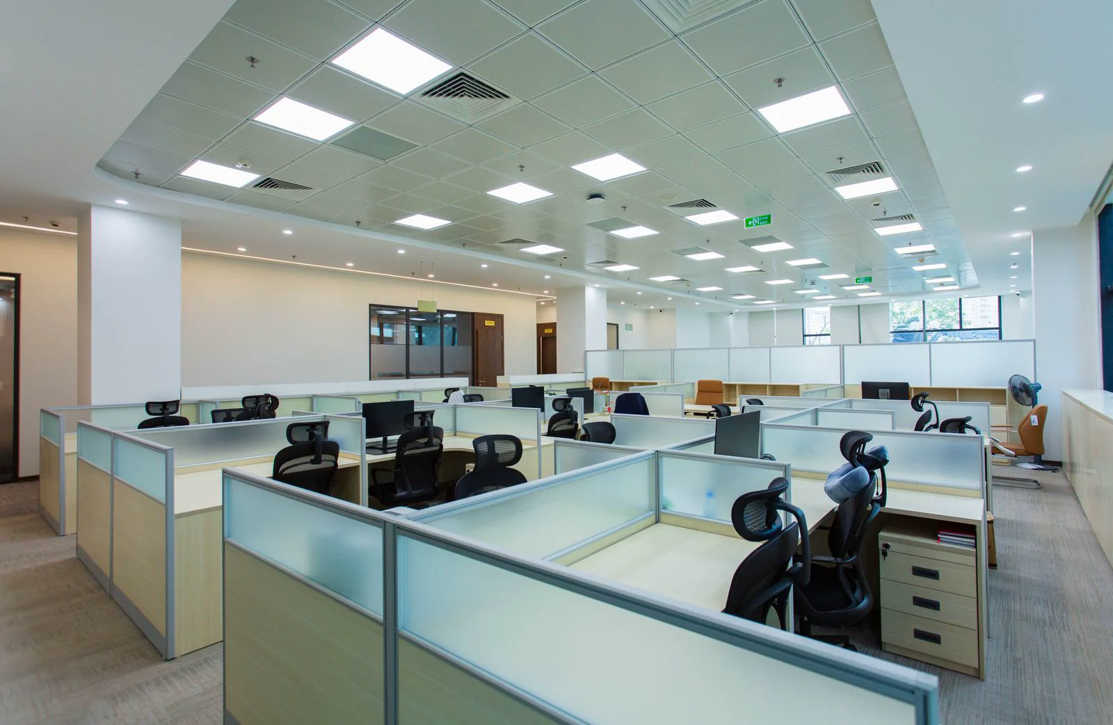 Bright modern open plan office interior with 300 to 500 lux task lighting on work surfaces