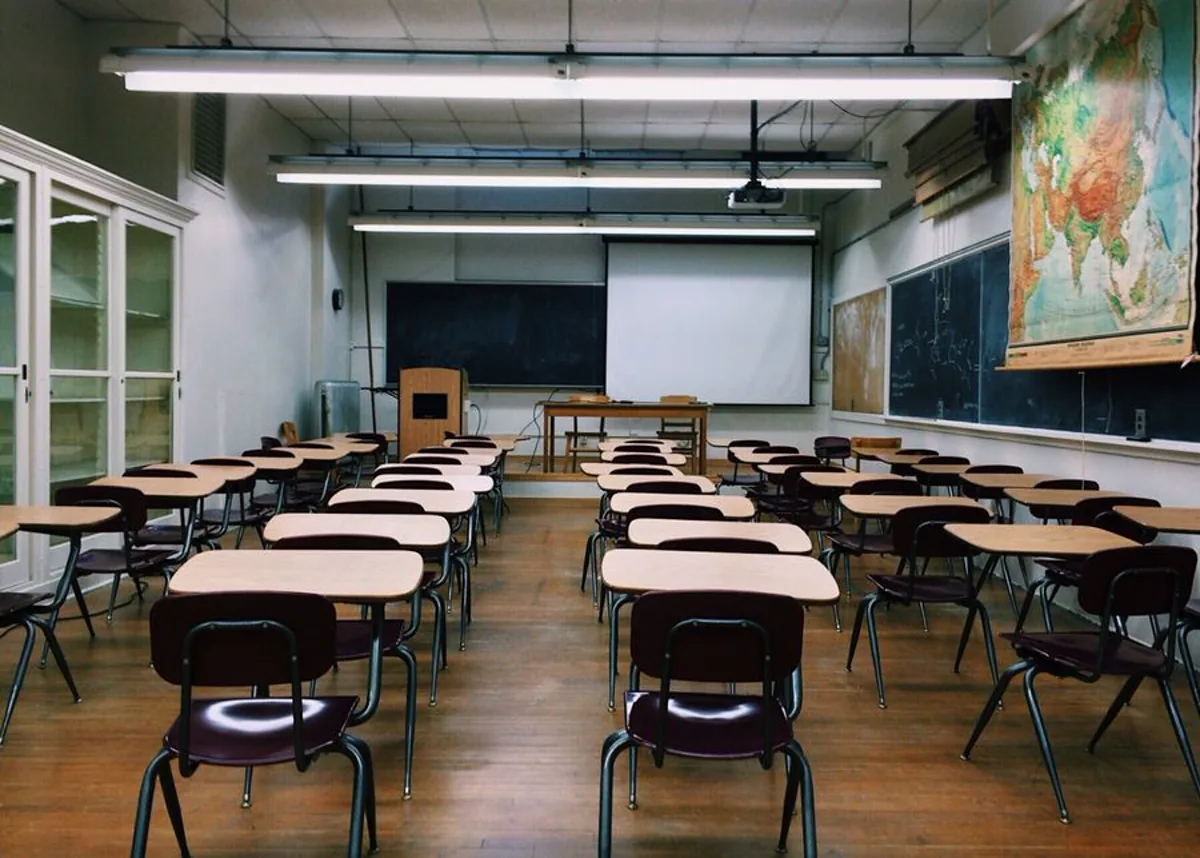 Modern secondary school classroom with continuous linear LED ceiling lighting over rows of desks for even task illuminance