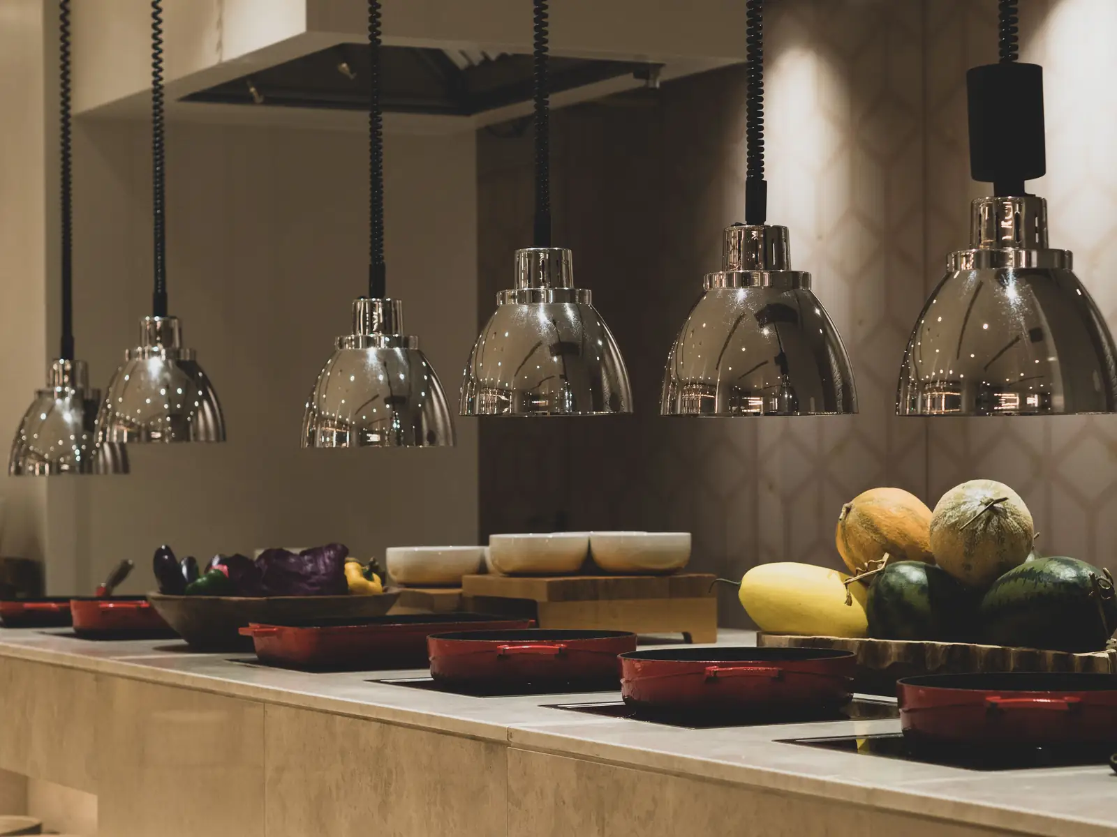 Restaurant countertop buffet with a row of pendant lights above the counter and the food display lit evenly at 2700K warm white