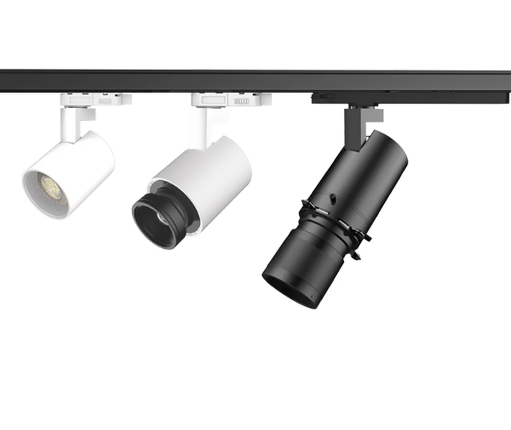 Three white and black track head optics compared under one retail display lighting track rail: standard spot, zoomable projection and framing projector