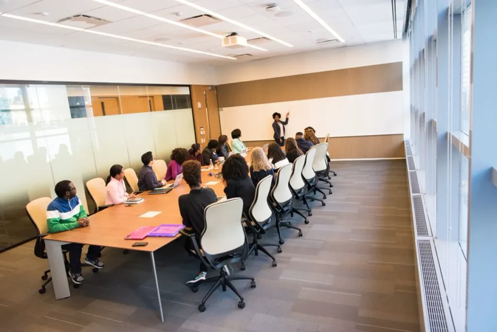 University lecture hall with tiered seating lit by layered school lighting track and even ceiling illumination