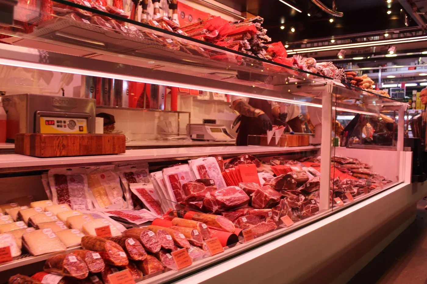 Fresh meat counter in a market deli under warm 3000K lighting, a surface where R9 above 80 is what keeps red meat looking red